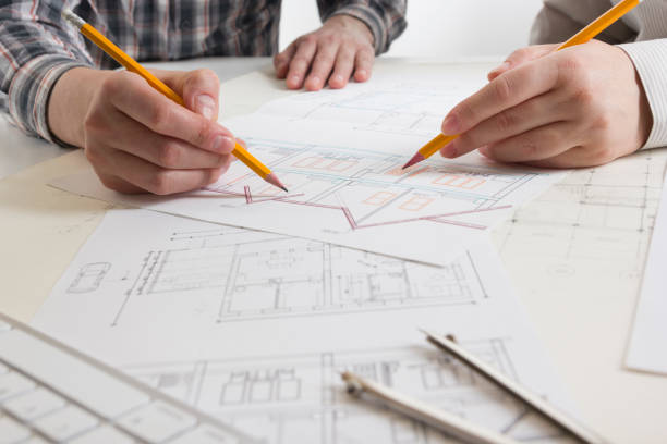 istock Architects working on blueprint, real estate project. Architect workplace - architectural project, blueprints, ruler, calculator, laptop and divider compass. Construction concept. Engineering tools. 1179994147