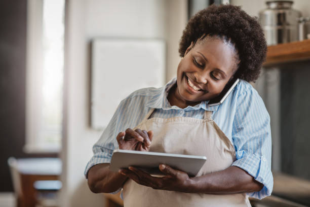 istock Smiling African American cook using a tablet and cellphone 1179995276