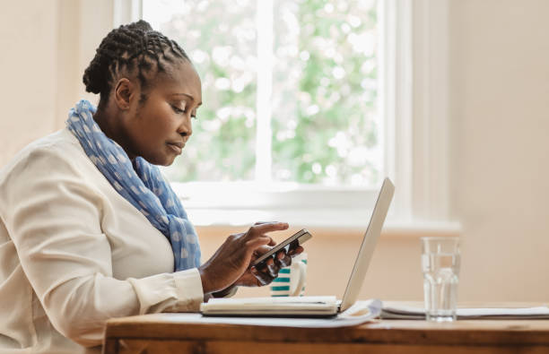 istock Focused African American female entrepreneur using her cellphone at home 1179999613
