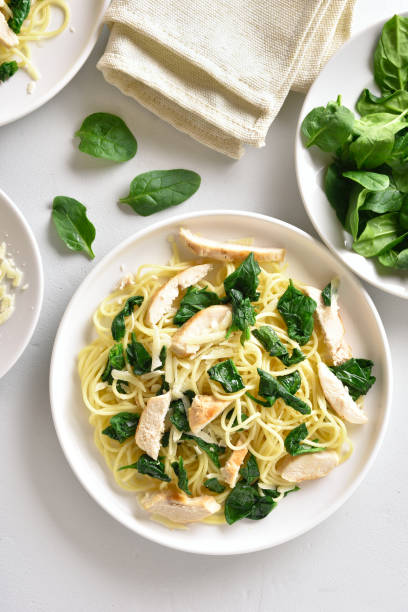 istock Spaghetti with spinach leaves, slices grilled chicken breast and grated cheese 1179999662