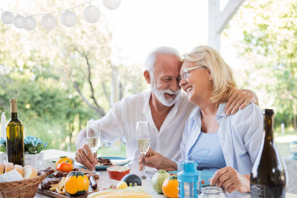 istock Elderly couple drinking wine enjoying their dinner 1180000454