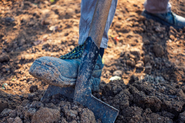 istock Man digging over loosening soil with a spade 1180000645