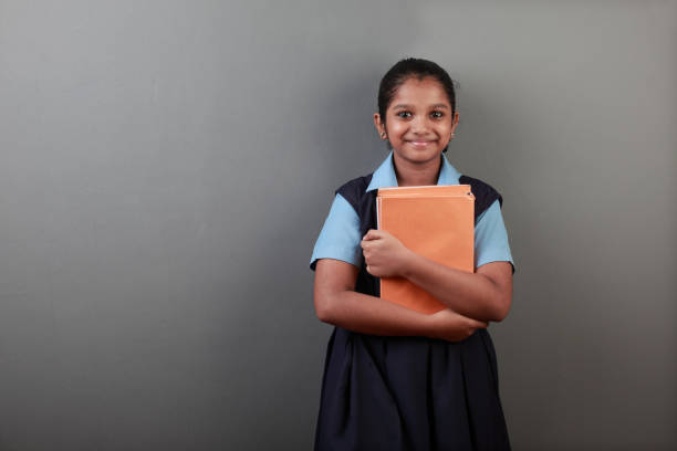 Portrait of young girl holding note books in her hands Portrait of young girl of Indian origin holding note books in her hands schoolgirl stock pictures, royalty-free photos & images