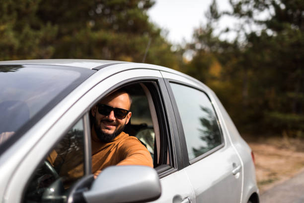 istock Young smiling man in his car 1180001692