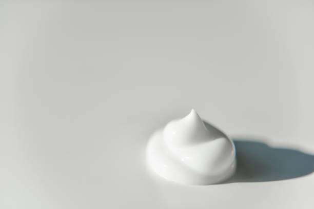 istock portion of white cream on grey white plain background with the side light 1180003314
