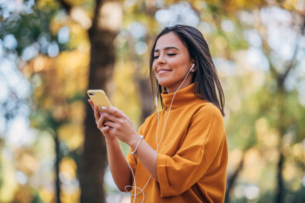 istock Beautiful woman using phone in park 1180004239