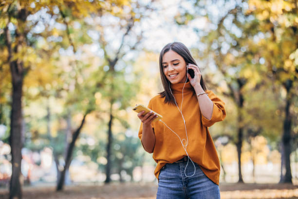 istock Young woman using phone in park 1180004441