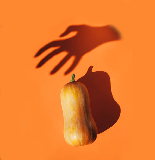 istock Spooky halloween flat lay of pumpkin and hand shadow. 1180004889