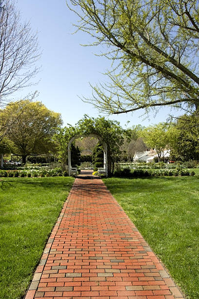 Brick Path Brick path leading through formal garden to covered gazbo-like structure. Blue sky. Early spring, Lewis Ginter Botanical Garden. Richmond, Virginia.Vertical.-For more Tent images, click here.  Tents tressle stock pictures, royalty-free photos & images