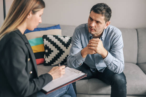 istock Mid age man having on on one counselling meeting 1180010613