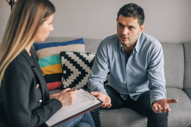 istock Mid age man having on on one counselling meeting 1180010664