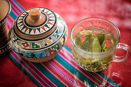 A cup of coca tea with coca leaves in Peru