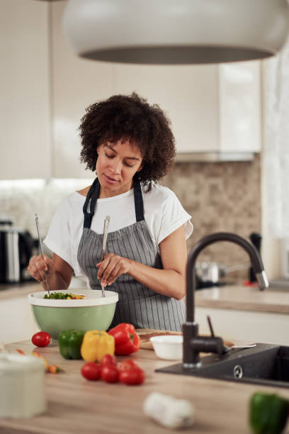 istock Woman mixing vegetables in bowl. 1180011637