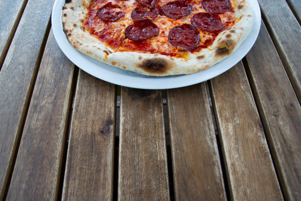 istock Pepperoni pizza on a wooden table. 1180012722
