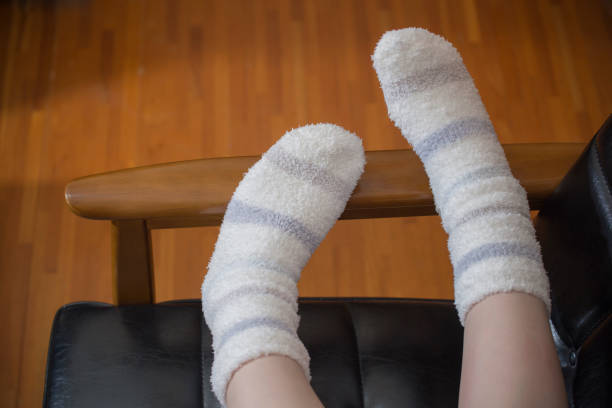 Women's legs wearing winter socks.\nFemale legs wearing winter socks.