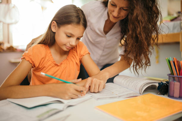 istock Girl doing homework with her mother at home 1180013291