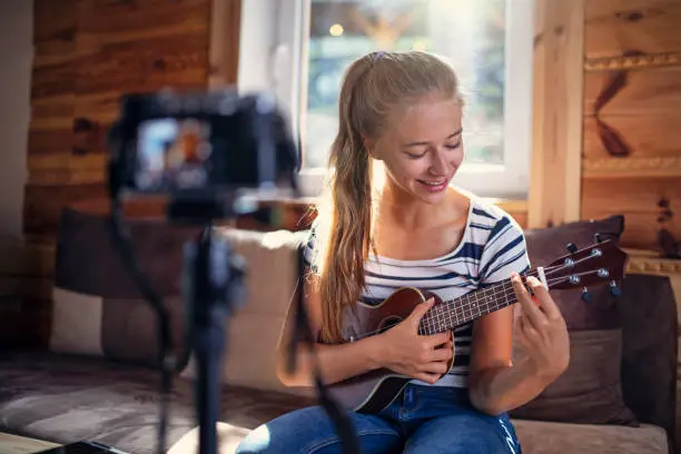 Teenage girl vlogger recording ukulele lesson for her video blog.
Nikon D850.