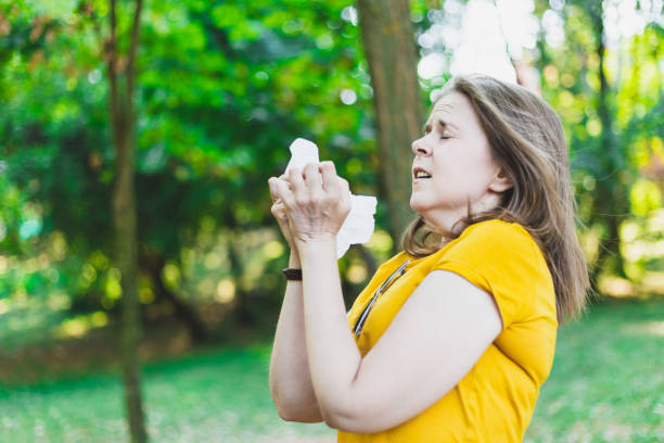istock Woman sneezing outdoors 1180014622