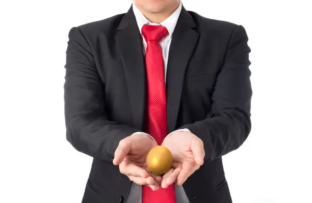 Photo of business man invest in gold egg