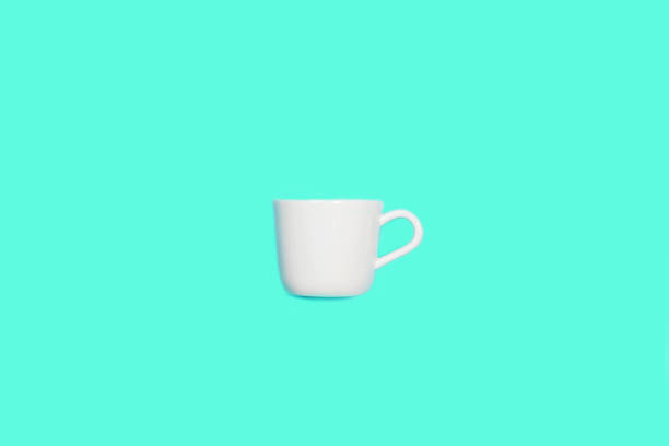 istock White cup for coffee on mint green blue color background. 1180014995