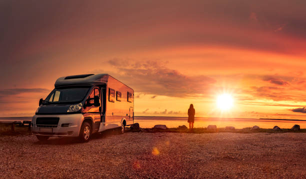 woman at sunset  with mobile home on the beach - rv imagens e fotografias de stock