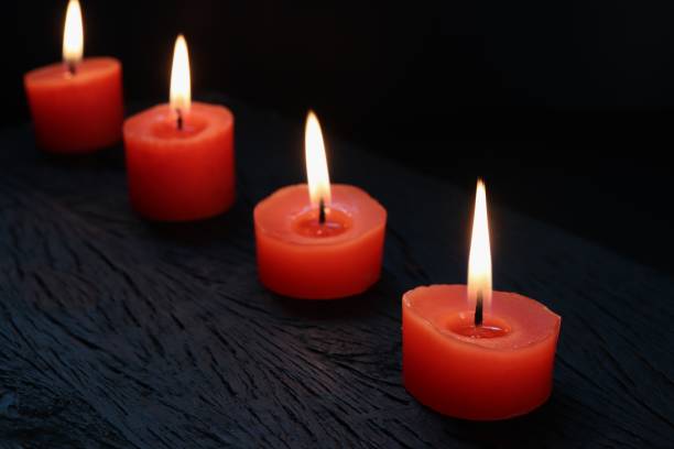 istock Burning red candles on black wooden background 1180017872