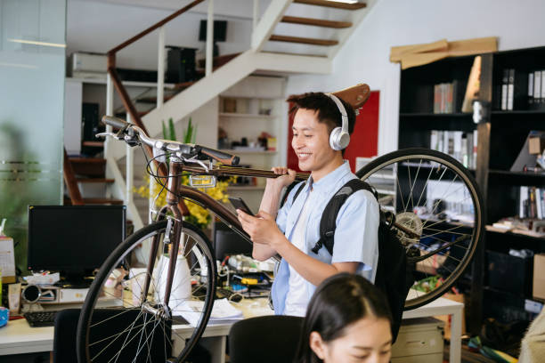 trabajador de oficina chino sonriente viajando para trabajar en bicicleta - china shanghai business people fotografías e imágenes de stock