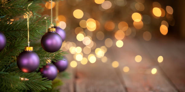 Christmas Tree with Purple Baubles and Gold Lights Background stock photo