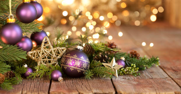 Christmas Purple Bauble and Gold Lights Background stock photo