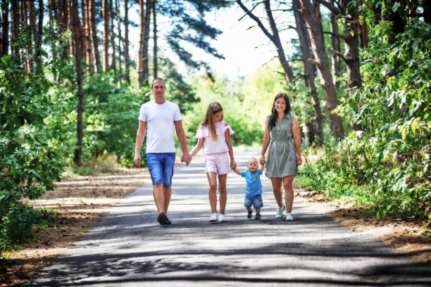 istock Family walking in summer park holding hands 1180018481