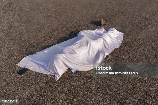 Concept Of Road Accident Scene High Angle View Of Chalk Outlined Dead Body Covered Under White Cloth Laying On Road Stock Photo - Download Image Now