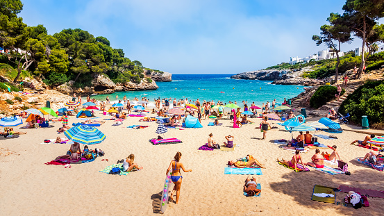 Santanyi Mallorca Spain July 2015 Tourists families playing relaxing and sunbathing on Cala Esmeralda Beach swimming in turquoise sea water holidays