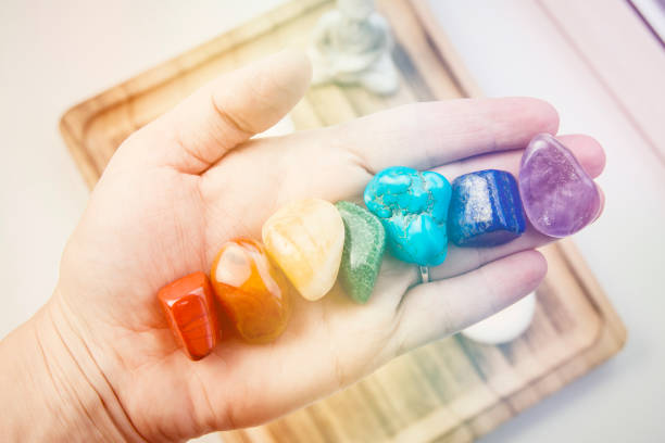 Woman hand sowing all seven color chakra crystal stones. Chakra energy flow healer concept. Woman hand sowing all seven color chakra crystal stones. Chakra energy flow healer concept. chakra photos stock pictures, royalty-free photos & images