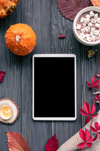 istock Autumn fall holiday background with pumpkin orange leaves cocoa cup tablet computer blank empty screen mock up on brown wooden table, happy halloween thanksgiving shopping sale, top vertical view 1180031231