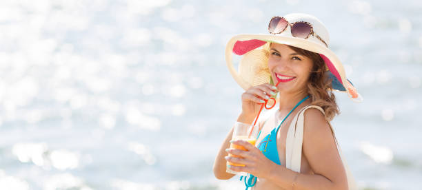 istock Sexy brunette with juice on the beach. 1180031240