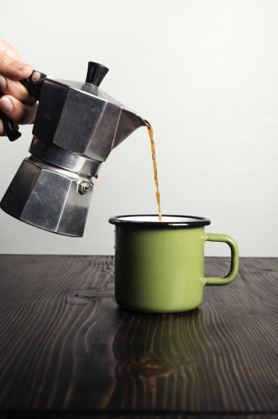 istock Hand close up pouring espresso coffee in a green cup 1180031699