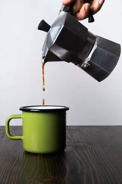 istock Hand close up pouring espresso coffee in a green cup 1180031761