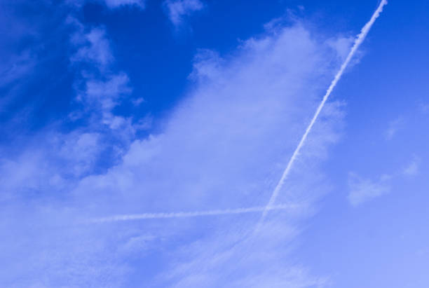 istock Blue sky with white clouds and lines from aircraft 1180033638