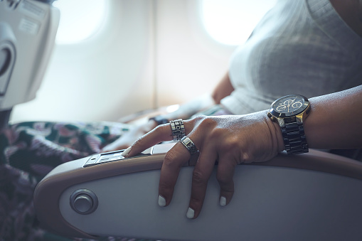 Woman adjusting airplane seat - Close up shot of hand