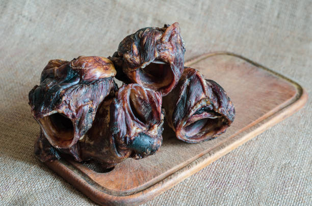 istock Several dried beef larynx on a wooden cutting board. 1180035273