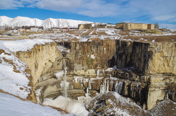 hermoso paisaje invernal del cañón tsolotlinskiy, cascada tobot, fortaleza de arani y montañas nevadas en el fondo. naturaleza y viajes. rusia, cáucaso norte, daguestán - extreme terrain eroded snow landscape fotografías e imágenes de stock