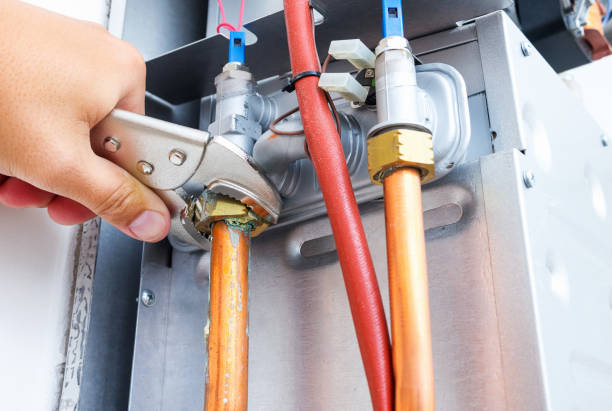 loodgieter repareren van een gasketel van een verwarming thuis systeem in de ketelruimte. close-up, selectieve focus. - cv stockfoto's en -beelden
