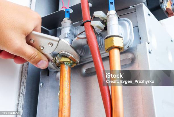 Plumber Repairing A Gas Boiler Of A Heating Home System In The Boiler Room Closeup Selective Focus Stock Photo - Download Image Now