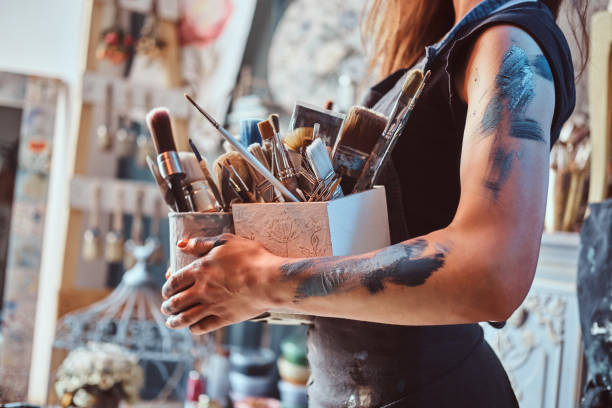 istock Young painter is tidying up after long working day 1180043836