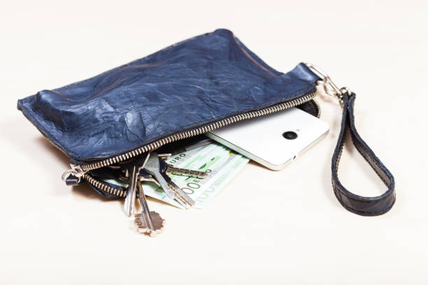 handbag with phone, keys and euro notes on table