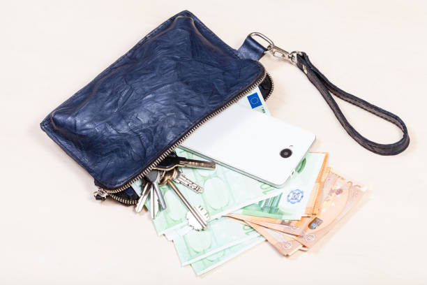 istock pouch with phone, keys and many euros on table 1180045502