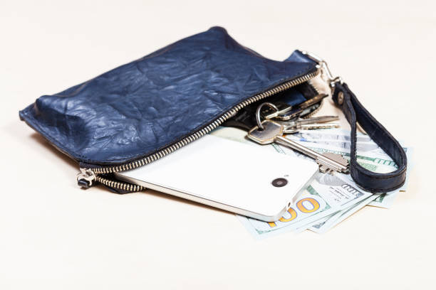 istock purse with phone, keys and US dollars on table 1180045510