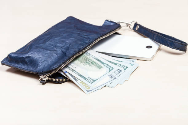 istock purse bag with phone and US dollars on table 1180045515