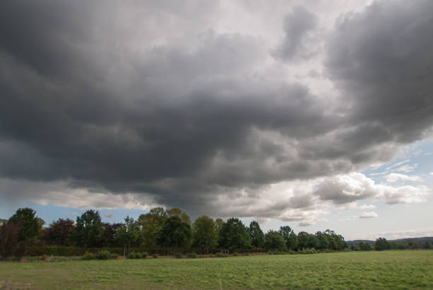 istock Dramatic rain clouds over a grove on the field edge. 1180046733