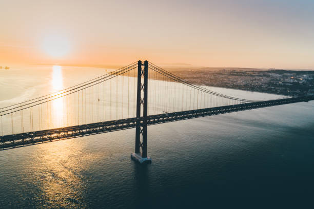 puente colgante con vista aérea sobre el río tajo en lisboa. - architecture blue bridge iron fotografías e imágenes de stock